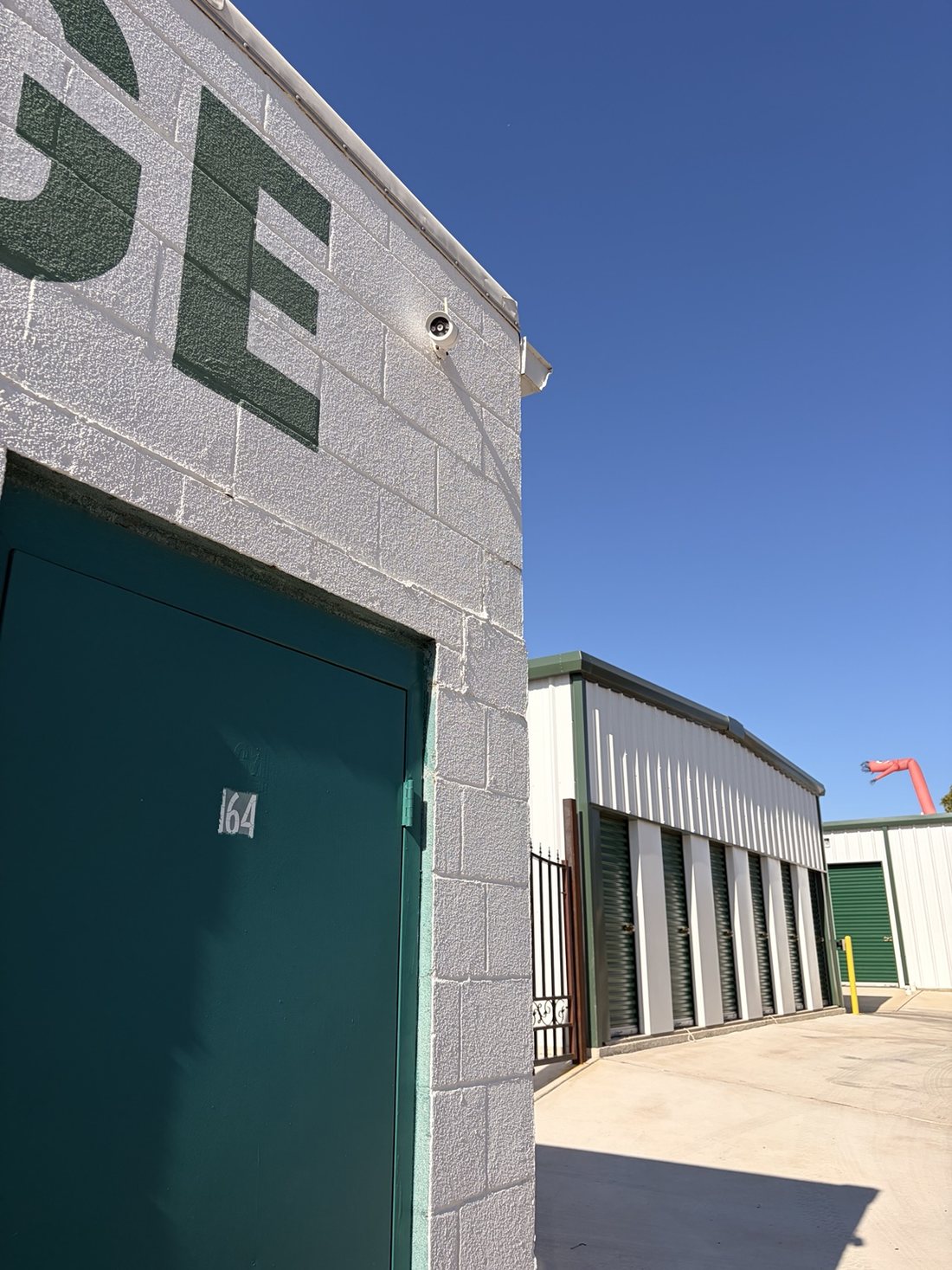 Security camera mounted above the green-door storage buildings at A-1 Self Storage in Fort Worth