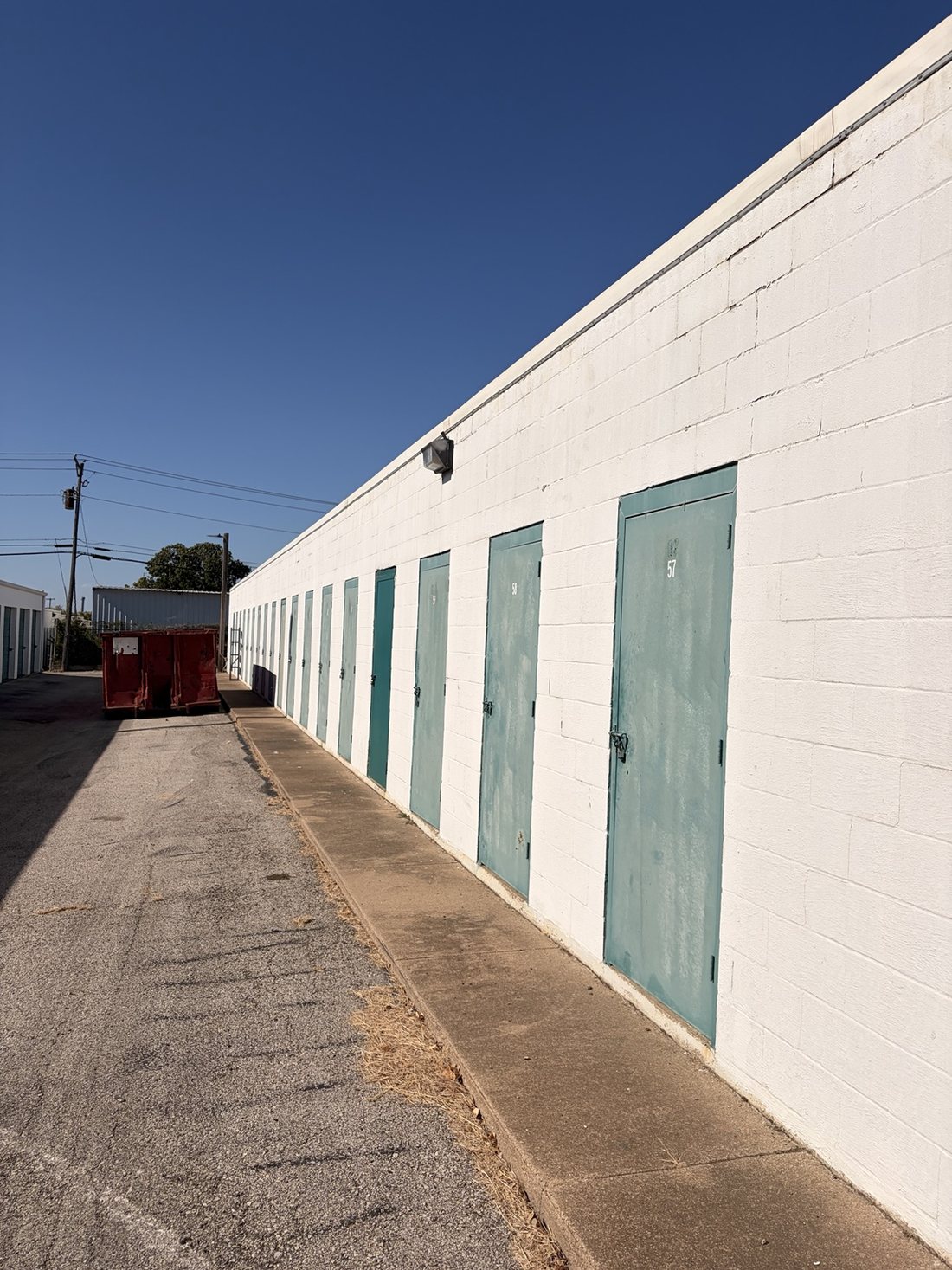 Drive aisle between blue-door storage buildings at A-Thrifti Self Storage near the Fort Worth Medical District